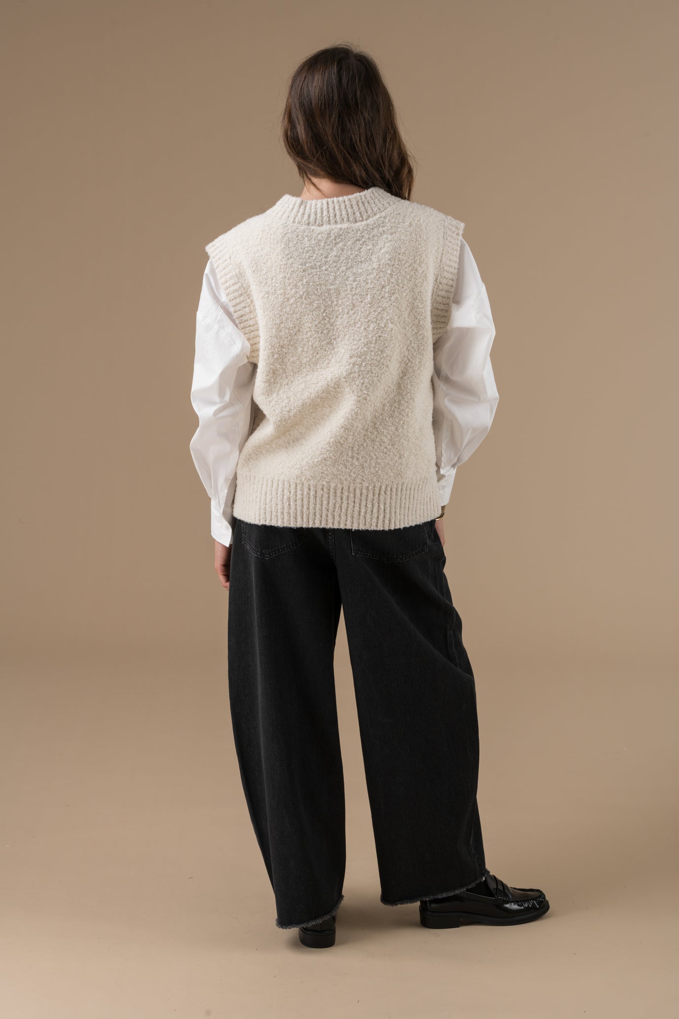 Pull Sian en maille avec un col en V, une pièce minimaliste et cosy, pensée pour les superpositions. Le pull Sian séduit par sa maille texturée et son encolure en V, qui apporte une touche de modernité à un essentiel du vestiaire. Son logo ton sur ton brodé à l’avant affirme discrètement l’identité d’Adoré Paris. Un basique revisité, facile à associer et parfait pour jouer les superpositions avec style.